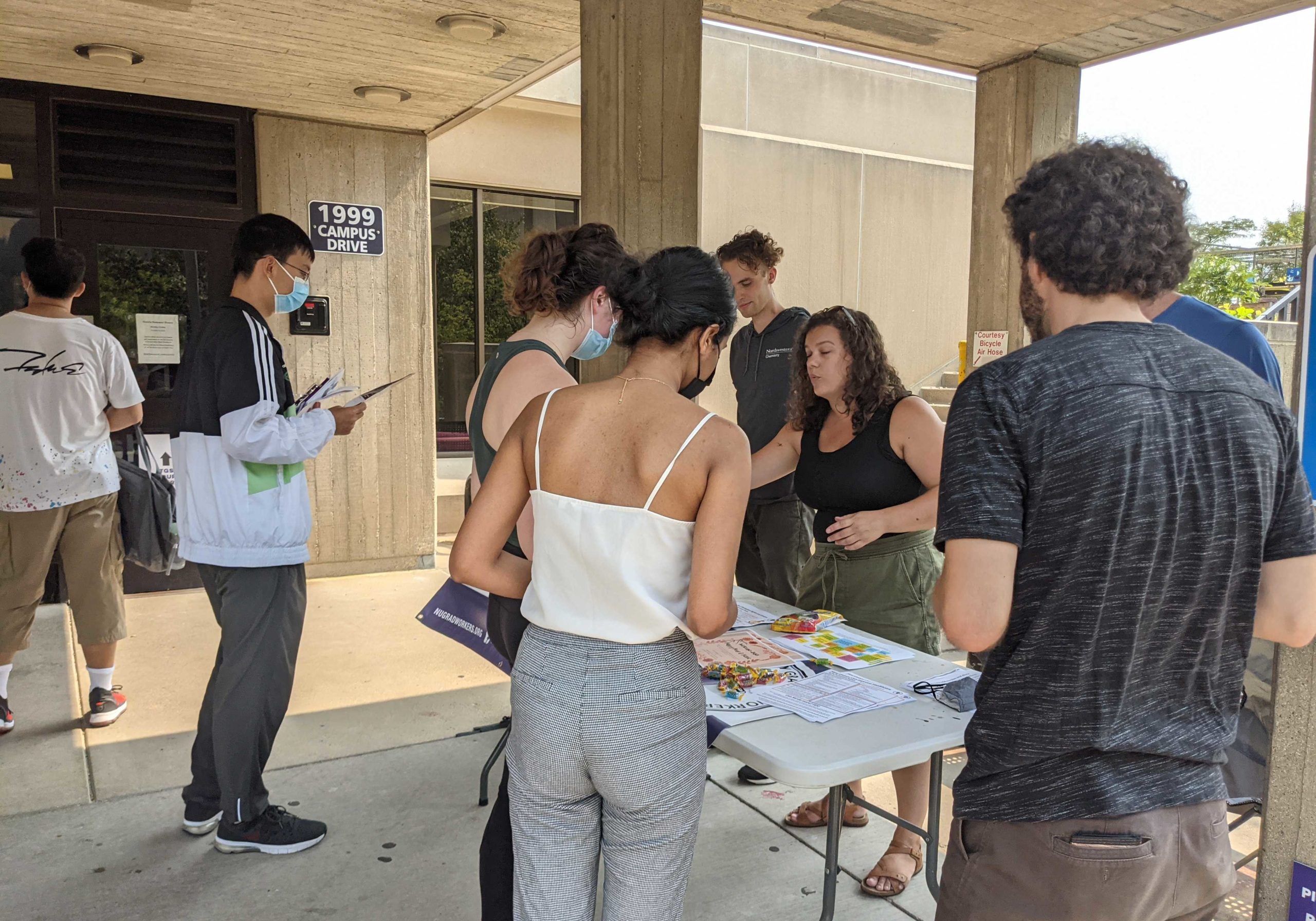 NUGW members passing out information about the union at a table on campus